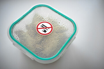 A plastic container with food that cannot be eaten. Warning logo that you can not eat.