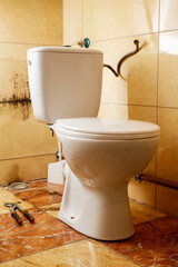 A plumber is repairing an old broken toilet.