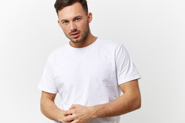 Serious angry young tanned handsome man in basic t-shirt fold hands posing isolated on over white studio background. Copy space Banner Mockup. People emotions Lifestyle concept