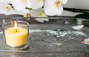 Obraz na płótnie Canvas Photo of a candle with rain, drops of water extinguishing the fire, splashes of water