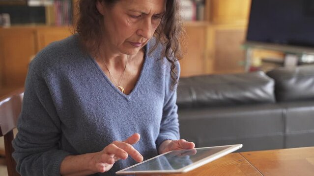 Technology savvy elderly woman learning to use tablet