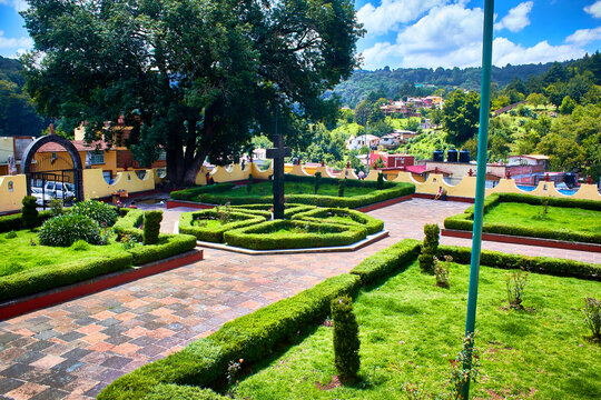 green garden with cross in the middel and trees around with mountains and forest in the background in el oro state of mexico 