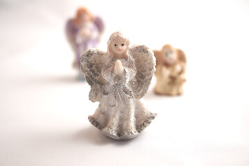 Three figurines of angels on a white surface