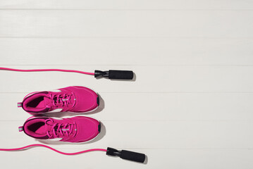 Fitness or bodybuilding concept on white wooden flooor background. Sport equipment for training at home. Photograph taken from above, top view with lots of copy space