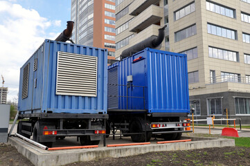 Industrial mobile diesel generator. Industrial diesel generator for an office building, connected to the electrical network by a cable. - obrazy, fototapety, plakaty