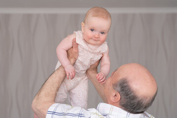 Grandfather holding a caucasian 8 month baby girl