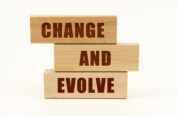 On a white surface are wooden blocks with the inscription - CHANGE AND EVOLVE
