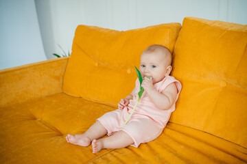 child on a yellow sofa with flowers at home