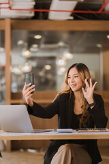 Asian businesswoman in formal suit in office happy and cheerful during using smartphone and working