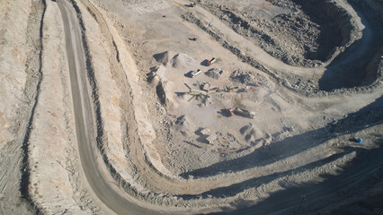 Fototapeta na wymiar Top view of sand quarry with excavators. Shot. Open pit mining operations with operating excavators. Mining industry concept