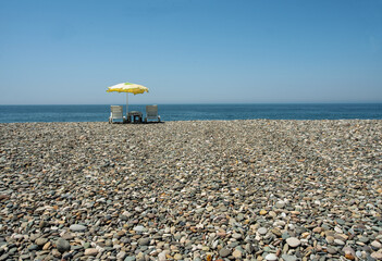 umbrella, chairs and a pebble beach on the wonderful coast of Georgia on the Black Sea