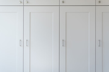 Modern new fitted tall cupboards in kitchen light grey color, interior trendy units. Huge storage...