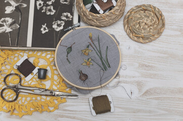 Process of making handmade embroidery. Hobby. Sewing tools. Remote home work. Daffodils botanical needle art.