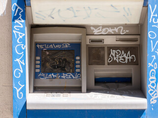 Old damaged destroyed vandalised outdoor ATM, vandalized cash machine detail, closeup. Economical...