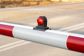 Simple rail crossing barrier red light, train crossing railroad station gate detail, closeup....
