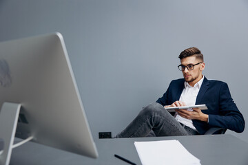 handsome businessman wearing glasses works in front of a computer isolated background