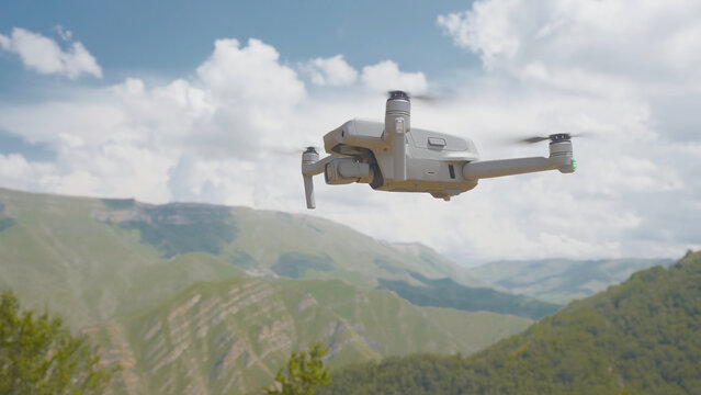 Quadcopter flies on background of mountains. Action. Quadcopter flies and shoots beautiful mountain landscapes. Quadrocopter takes pictures of green mountain valley