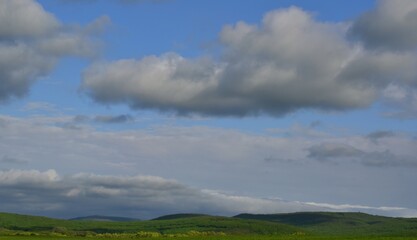 Dense clouds rise above the hills covered with greenery.Sunny day.Spring. Krasnodar region .Russia.