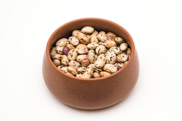 Bean grains in a clay pot on a white background. Close-up