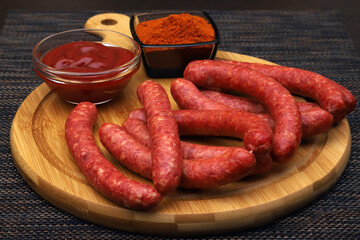 hunting sausages on a serving board with ground pepper and tomato sauce. Shallow depth of field