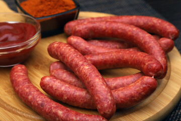 hunting sausages on a serving board with ground pepper and tomato sauce. Shallow depth of field