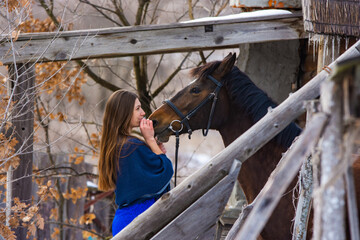 Portrait of a happy girl hugging a horse, the girl joyfully looks at the horse