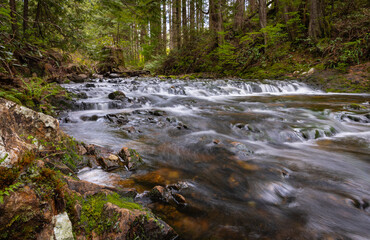 Beautiful mountain rainforest waterfall with fast flowing water and rocks, long exposure.