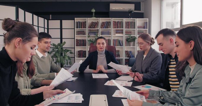 Stressed Female Boss And Workers Discussing Issues At Business Meeting