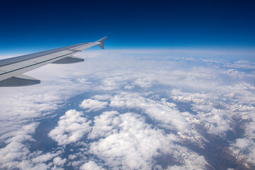 Fototapeta na wymiar View from an airplane window on clouds and blue sky