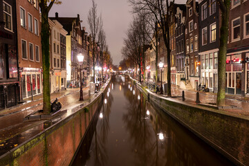 AMSTERDAM, NETHERLANDS - DECEMBER 12, 2021. Dutch houses  at night Christmas time in the old city.
