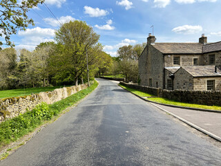 Fototapeta na wymiar Looking along, Carr Head Lane, with dry stone walls, cottages, farms, and old trees in, Cowling, Keighley, UK