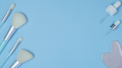cosmetic accessories on a blue background. makeup brushes close-up. pattern with cosmetics. top view, flat lay.