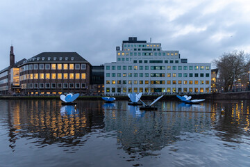 Obraz premium Amsterdam Netherlands on December 13, 2021: City scenic from Amsterdam at the Amstel in the Netherlands at night. Amsterdam Light Festival Boat Tour in Christmas.