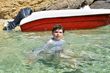 child in the water near the boat