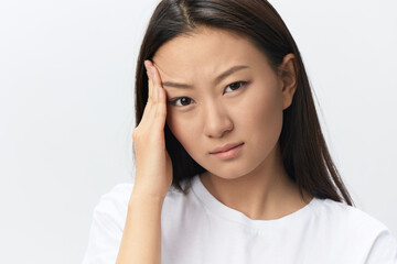 Fototapeta premium Migraine. Side view of unhappy suffering from headache tanned beautiful young Asian woman touching forehead posing isolated on white background. Injuries Poor health Illness concept. Cool offer Banner