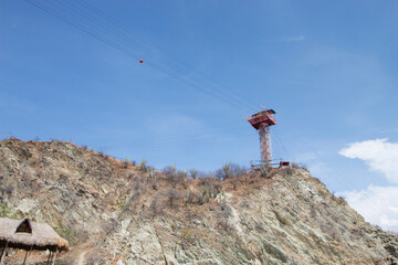 SANTA MARTA, COLOMBIA - Canopy tower at the top of rocky cliff in White beach sunny day