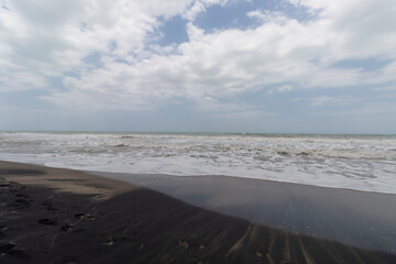 Colombian palomino beach landscape with black sand and cloudy day at background