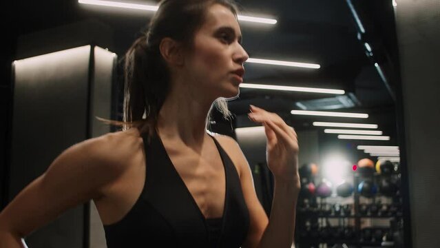 Total body kettlebell workout. Young nice-looking fit female Caucasian athlete doing workout, training with weight kettlebell in gym. Muscular pretty woman at fitness training.