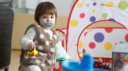 Happy one year old baby playing at home