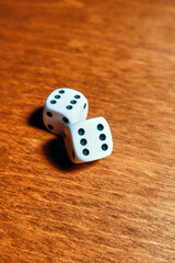 Close-up of two dice with rolled sixes on a wooden table