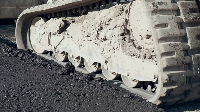 
excavator tracks at road works close up