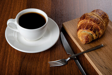 Croissant with a cup of full coffee,directly above	