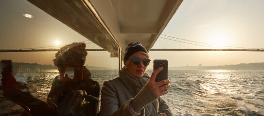 Young amazing woman outdoors on boat in sea take a selfie