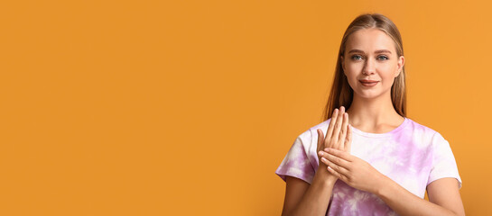 Young deaf mute woman using sign language on orange background with space for text © Pixel-Shot