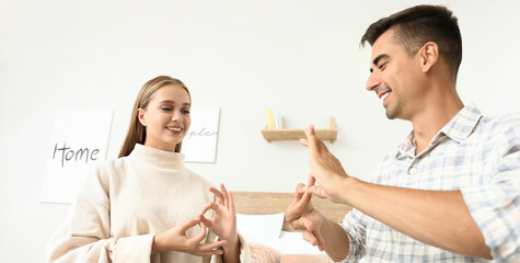 Young deaf mute couple using sign language at home