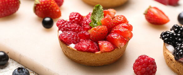 Tasty berry tartlet on board, closeup