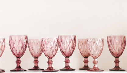 Stylish empty glasses on table against white background