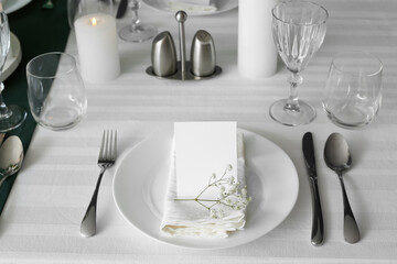 Stylish table setting for wedding celebration with invitation card