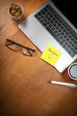 Illustration du bien-être et du bonheur au travail. Un papier autocollant est collé sur un ordinateur portable avec le mot bonjour et un sourire dessiné. © Tof - Photographie