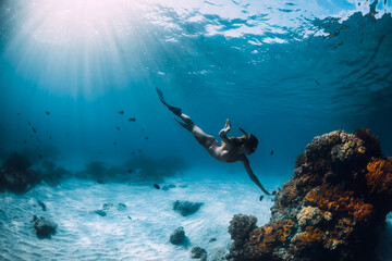 Beautiful girl freediver and corals. Freediving in ocean at Hawaii islands
